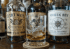 Scotch vs Whiskey vs Bourbon: A Beginner’s Guide three bottles with curling labels, cracked glass with compass pool